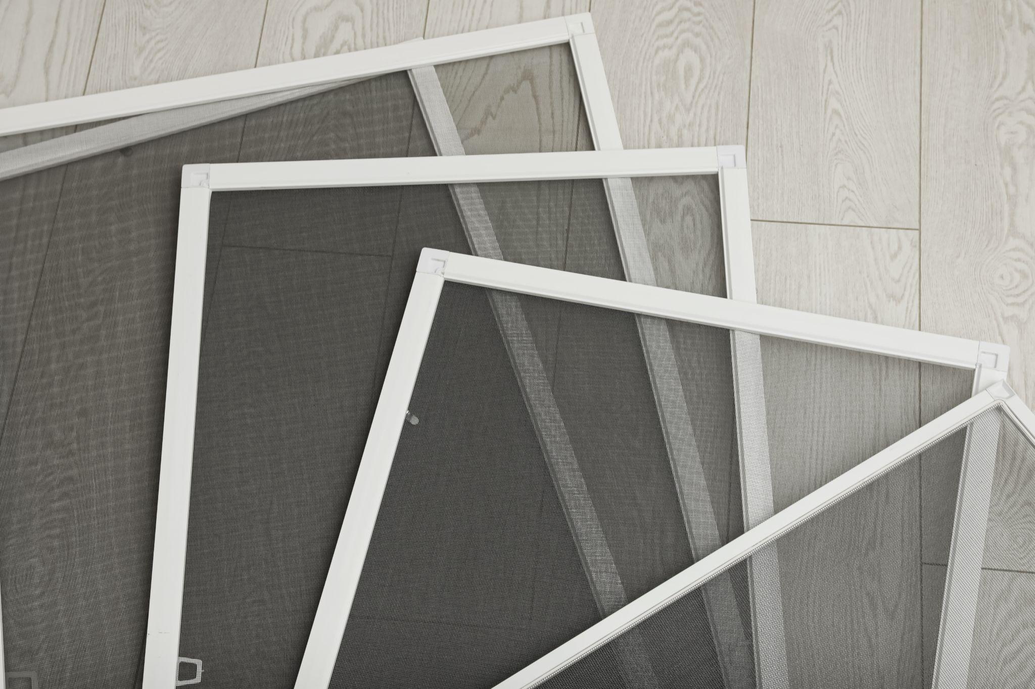 Set of window screens on wooden floor